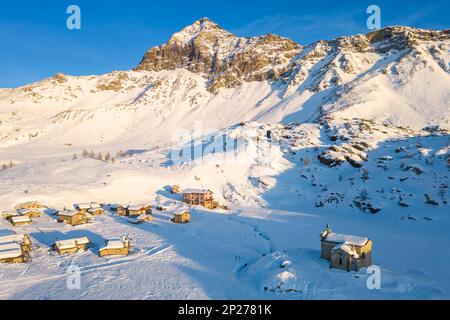 Coucher de soleil devant Rifugio Cristina et Pizzo Scalino en hiver. Lanzada, Valmalenco, Valtellina, quartier de Sondrio, Lombardie, Italie, Europe. Banque D'Images