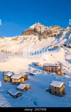 Coucher de soleil devant Rifugio Cristina et Pizzo Scalino en hiver. Lanzada, Valmalenco, Valtellina, quartier de Sondrio, Lombardie, Italie, Europe. Banque D'Images