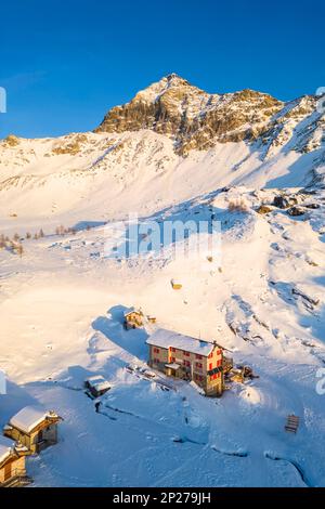 Coucher de soleil devant Rifugio Cristina et Pizzo Scalino en hiver. Lanzada, Valmalenco, Valtellina, quartier de Sondrio, Lombardie, Italie, Europe. Banque D'Images