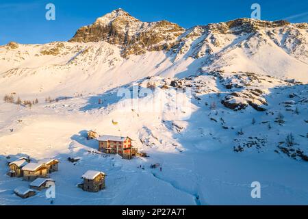 Coucher de soleil devant Rifugio Cristina et Pizzo Scalino en hiver. Lanzada, Valmalenco, Valtellina, quartier de Sondrio, Lombardie, Italie, Europe. Banque D'Images