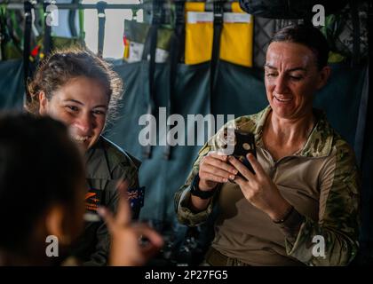 Membre de la Royal Australian Air Force et des États-Unis Airman divertit des enfants lors d'un événement d'engagement communautaire au cours de Cope North 2023 à Rota, dans les îles Mariannes du Nord, près de la base aérienne d'Andersen, Guam, le 17 février 2023. COPE North 23 améliore les relations américaines avec nos alliés et partenaires régionaux en favorisant l'échange d'informations et en affinant les tactiques, techniques et procédures communes afin de mieux intégrer les capacités de défense multinationales. Banque D'Images