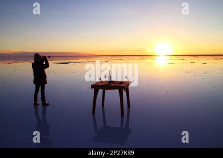 Voyageur célébrant lors des inondations salées, l'emblématique effet miroir de Salar de Uyuni au coucher du soleil, département de Potosi, Bolivie Banque D'Images