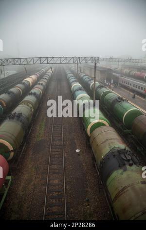 Plusieurs lignes de de wagons-citernes à la gare dans un brouillard. Paysage russe industrielle dépressifs avec beaucoup de trains de marchandises Banque D'Images