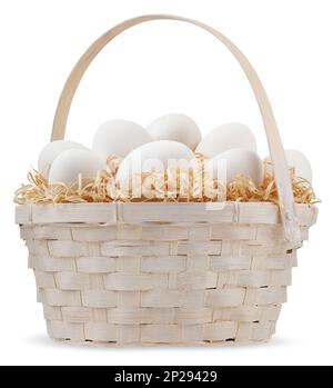 Joyeuses Pâques décorations, panier en osier plein d'oeufs blancs sur nid de paille isolé sur fond blanc, modèle pour étiquette, carte de voeux cadeau, adverti Banque D'Images