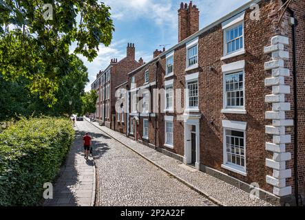 Rouge ou terrasse de vieux bâtiments historiques en briques sur une rue pavée dans le parc de la cathédrale de Chester, Angleterre, Royaume-Uni Banque D'Images