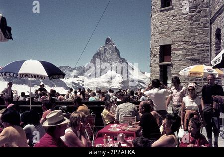 Les clients du Kulmhotel sont assis sur la terrasse de l'hôtel. En arrière-plan le Cervin. Gornergrat, Zermatt, Valais, Suisse, 1975 Banque D'Images