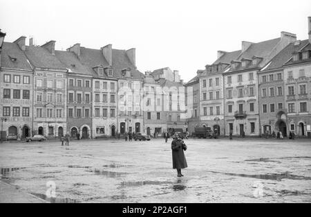 Une femme se tient sur la place du marché de la vieille ville, centre historique de Varsovie, capitale de Varsovie, Masovian Voivodeship, Pologne, mars 1956 Banque D'Images