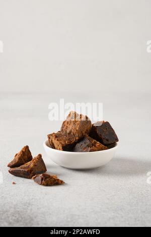 Kithul jaggery et sirop de mélasse sucré naturel dans un bol sur fond gris. Sucre de remplacement et superaliment à faible indice glycémique. ECO produ basé sur Palm Banque D'Images