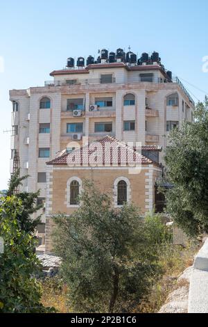 Ramallah, Ramallah et gouvernorat d'al-Bireh, Palestine, 28 juillet 2022 : ancien bâtiment résidentiel en pierre blanche sur une colline avec de nombreux réservoirs d'eau noire Banque D'Images