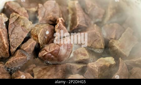 Poumon de porc dans de l'eau chaude bouillie. Gros plan sur la préparation d'un plat thaïlandais. Poumons de boeuf ou de boeuf bouillis, entrailles de porc. Banque D'Images