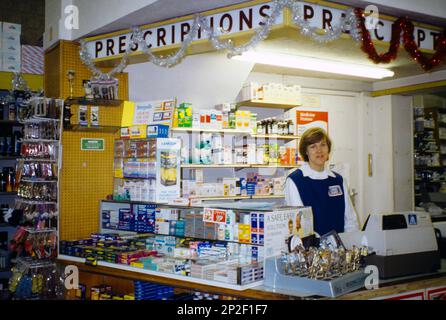 Pharmacie distributeur pharmacie comptoir femme travaillant par Till Surrey Angleterre Banque D'Images