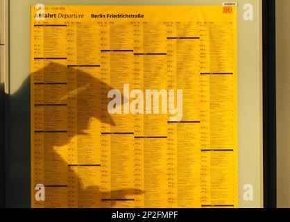 Berlin, Allemagne. 01st mars 2023. L'ombre d'un homme regardant l'affichage de son smartphone tombe sur la carte du départ de la gare de Berlin-Friedrichstraße dans l'après-midi. Crédit : Soeren Stache/dpa/Alay Live News Banque D'Images