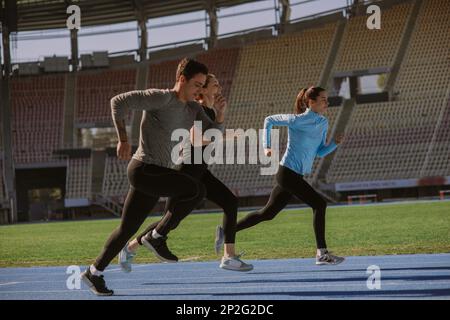 Un homme fait du jogging au stade avec ses deux magnifiques amies Banque D'Images