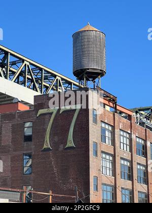 Tour d'eau sur le toit, au sommet d'un bâtiment tapé par un entrepôt, dans la section Gowanus de Brooklyn, New York. Banque D'Images