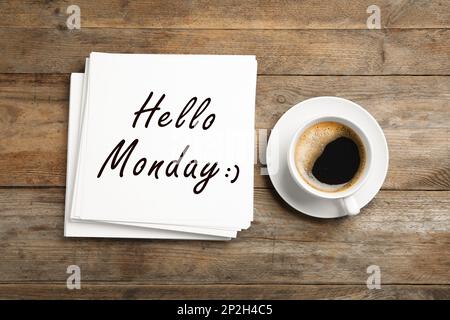 Commencez votre semaine de bonne humeur. Feuilles de papier avec texte Bonjour lundi et tasse de café sur table en bois, plat Banque D'Images