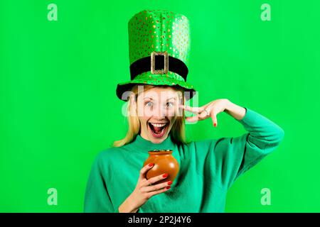 Fille de Saint Patrick. Femme Patrick dans le chapeau vert avec pot d'or. Femme souriante dans le chapeau Leprechaun avec pot d'or. Bonne Saint Patrick. Blond Banque D'Images