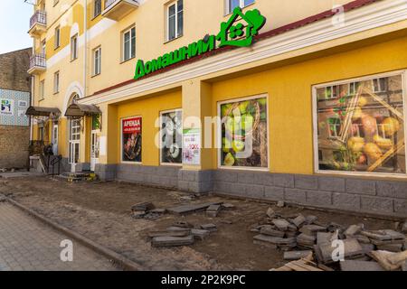 Grodno, Bélarus - 06 mars 2022: Des travailleurs avec l'aide d'équipements de terrassement reconstruisent des services publics souterrains dans l'une des rues les plus anciennes Banque D'Images