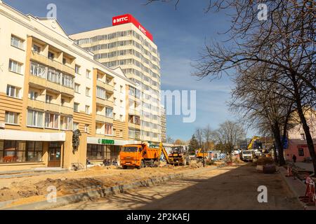 Grodno, Bélarus - 06 mars 2022: Des travailleurs avec l'aide d'équipements de terrassement reconstruisent des services publics souterrains dans l'une des rues les plus anciennes Banque D'Images