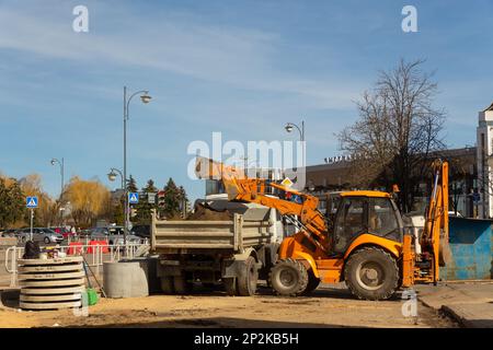 Grodno, Bélarus - 06 mars 2022: Des travailleurs avec l'aide d'équipements de terrassement reconstruisent des services publics souterrains dans l'une des rues les plus anciennes Banque D'Images