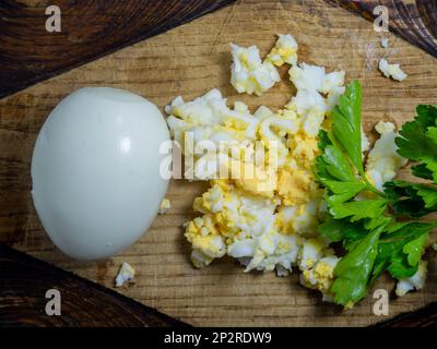 Protéines d'œuf râpées. produit protéique. Préparation de salade. Œuf dur râpé sur une planche à cuisine. Entier Banque D'Images