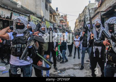 Naplouse, Palestine. 04th mars 2023. Des hommes armés palestiniens masqués du bataillon de Balata détiennent leurs armes lors d'une cérémonie de commémoration de deux Palestiniens qui ont été tués par l'armée israélienne il y a un mois, dans le camp de réfugiés de Balata, à l'est de Naplouse, en Cisjordanie. De nombreuses factions et militants palestiniens présentent leurs armes et leur force pendant toute la cérémonie de commémoration pour les Palestiniens qui sont tués par l'armée israélienne, afin de montrer l'étendue de leur force à l'armée israélienne. Crédit : SOPA Images Limited/Alamy Live News Banque D'Images