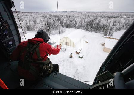 Les gardes de l'Armée de l'Alaska, avec le détachement 2, 2-211th général appui Aviation Bataillon, aident les aviateurs de tactiques spéciales, affectés à la 24th Escadre des opérations spéciales, détachement 1, avec une évacuation médicale et une formation de palan au Camp Mad Bull sur la base interarmées Elmendorf-Richardson, Alaska, le 10 janvier 2023. Le bataillon de soutien général de l’aviation de la Garde nationale de l’Armée de l’Alaska s’entraîne régulièrement avec toutes les branches de l’armée et les organismes civils pour accroître son interopérabilité opérationnelle et être prêt à accueillir une vaste gamme de missions fédérales et d’État. Banque D'Images