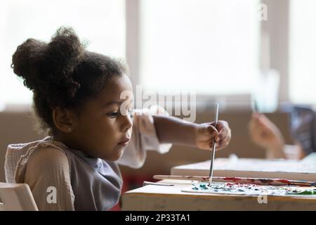 École artistique sérieuse African American pupille fille peinture sur toile Banque D'Images