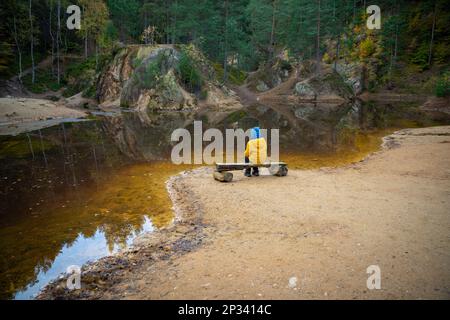 L'enfant repose sur un banc au bord du lac au milieu de la forêt. Montagnes polonaises Banque D'Images