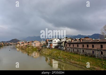 Srinagar, Inde. 04th mars 2023. Des maisons résidentielles sont vues sur les rives de la rivière Jehlum pendant un temps nuageux dans la vieille ville de Srinagar, la capitale estivale de Jammu-et-Cachemire. Crédit : SOPA Images Limited/Alamy Live News Banque D'Images