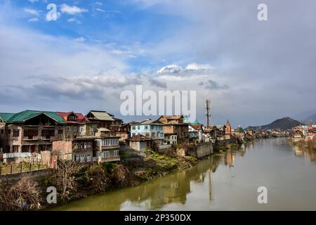 Srinagar, Inde. 04th mars 2023. Des maisons résidentielles sont vues sur les rives de la rivière Jehlum pendant un temps nuageux dans la vieille ville de Srinagar, la capitale estivale de Jammu-et-Cachemire. Crédit : SOPA Images Limited/Alamy Live News Banque D'Images