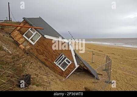 Des falaises de mer érodées et un chalet endommagé après la marée en décembre 2013, Hemsby, Norfolk, Angleterre, Royaume-Uni Banque D'Images