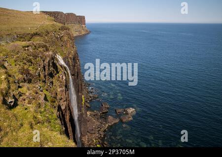 Vue sur la côte avec une chute d'eau en cascade sur les falaises dans la mer avec Kilt Rock en arrière-plan, Mealt Falls, près de Sound of Raasay Banque D'Images