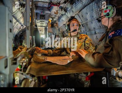 ÉTATS-UNIS Le capitaine de la Force aérienne, Shailey Dao, infirmière de vol, reçoit une formation d'un membre de la Royal Australian Air Force à bord d'un C-27J Spartan pour une formation d'intervention d'urgence au cours de COPE North 2023 près de la base aérienne d'Andersen, Guam, le 14 février 2023. Les États-Unis, l'Australie et le Japon ont recours à l'interopérabilité au cours du COPE North 23 grâce à une production agile et intégrée d'énergie aérienne à partir de sites dispersés dans l'Indo-Pacifique, démontrant ainsi la résilience et la capacité de survie de la coalition dans un environnement contesté. Banque D'Images