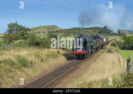 Train à vapeur et calèches, passant par le parcours d'or avec la ville balnéaire en arrière-plan, North Norfolk Railway, Sheringham, Norfolk, Angleterre, Unis Banque D'Images