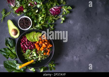 Salade de quinoa dans un bol avec avocat, patate douce, haricots, herbes, spinat sur fond de béton rustique. Quinoa Superfood concept. Détox sain et propre Banque D'Images