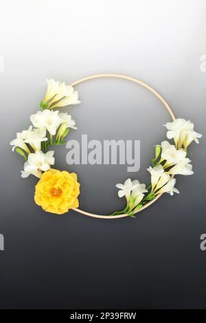 Couronne florale pour en memorium carte de sympathie avec freesia et fleur rose et cadre en bois. Symbole de logo rond de forme de condoléances minimum sur dégradé de gris Banque D'Images