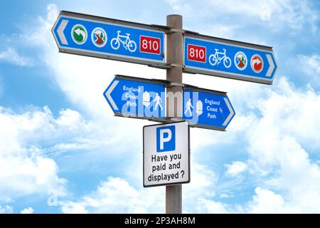 des signes de direction bleus pour le sentier côtier de l'angleterre, la route à vélo 810, et un panneau de stationnement vous ont payé et affiché à crosby merseyside Banque D'Images