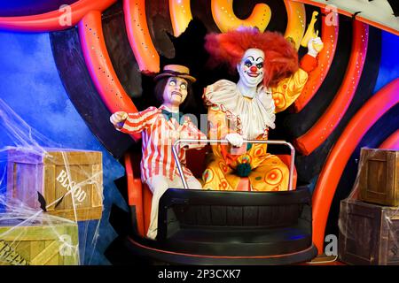 Deux poupées clown souriantes regardant dans la caméra avec un pistolet soulevé dans leur main. Photo de haute qualité Banque D'Images