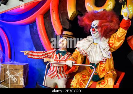 Les clowns de poupée sont assis dans un chariot et agitant leurs bras pointant dans la direction. Effrayant. Halloween. La chasse. Photo de haute qualité Banque D'Images