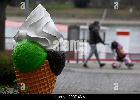 05 mars 2023, Rhénanie-du-Nord-Westphalie, Königswinter : les randonneurs passent une glace surdimensionnée devant un café glacé sur les rives du Rhin. Toutefois, les météorologues prévoient des températures froides avec la pluie pour la semaine suivante. Le printemps est encore loin. Photo: Roberto Pfeil/dpa Banque D'Images