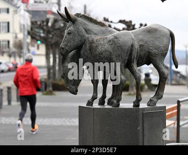 05 mars 2023, Rhénanie-du-Nord-Westphalie, Königswinter : un jogging passe devant la fontaine Eselsbrunnen sur les rives du Rhin. Les météorologues prévoient des températures froides avec la pluie pour la semaine suivante. Le printemps est encore loin. Photo: Roberto Pfeil/dpa Banque D'Images