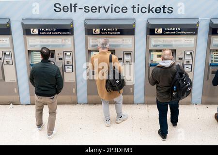 Les gens utilisent une machine à billets à la gare de Waterloo à Londres. Les passagers ferroviaires ont été frappés par la plus grande hausse des tarifs depuis plus d'une décennie, malgré une fiabilité record. Les tarifs en Angleterre et au pays de Galles ont augmenté le dimanche jusqu'à 5,9 % en moyenne, ce qui a ajouté des centaines de livres au coût de nombreux billets de saison annuels. Date de la photo: Vendredi 3 mars 2023. Banque D'Images