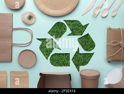 Le papier est découpé avec un symbole de recyclage révélateur d'herbe au milieu d'une collection d'emballages écologiques à faible teneur en carbone Banque D'Images