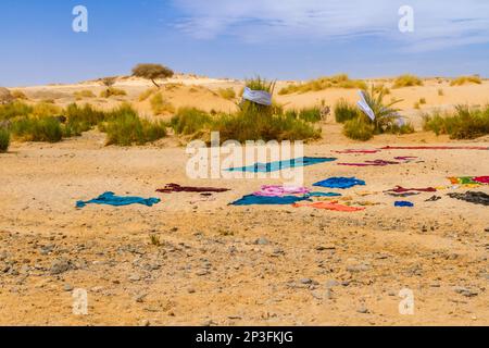 Tuareg femmes lavées à sec les clothers de manière traditionnelle. Linge coloré séchant au soleil sur le sable. Parc national de Tassili n'Ajjer, Algérie, Sahara, Afrique Banque D'Images