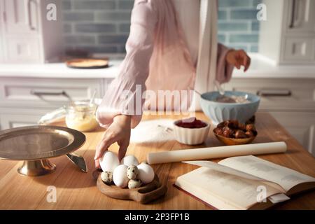 Fermez les mains des femmes pour pétrir la pâte dans la cuisine. Une femme se fait cuire une tarte ou un gâteau à la maison Banque D'Images