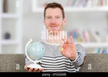 homme montrant la carte sim et le globe se concentrent sur les mains Banque D'Images