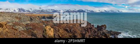 Village sur la côte de l'Islande surplombant la mer agitée et les nuages pittoresques en arrière-plan. Banque D'Images