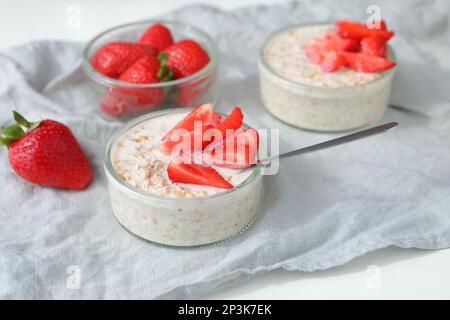 Petit déjeuner sain : deux portions de muesli avec du lait et des tranches de fraises fraîches Banque D'Images