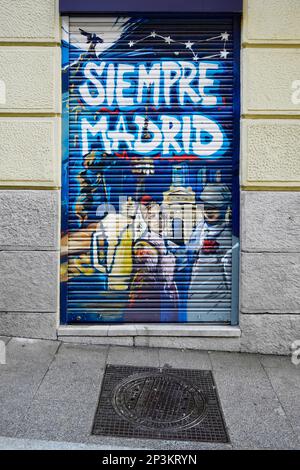 Madrid, Espagne - 23 février 2023: graffitis à la porte d'un magasin de madrid avec le plus respectable peint avec une couverture typique de trou d'homme de la ville Banque D'Images