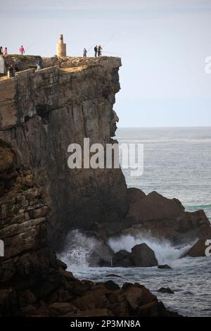 Pêcheurs au sommet des falaises d'Ilheu da Paloa avec des vagues de l'océan Atlantique s'écrasant en contrebas, Peniche, région centrale, Portugal, Europe Banque D'Images